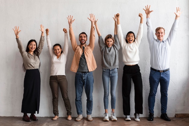 Gente sonriente poniendo sus manos en una sesión de terapia de grupo