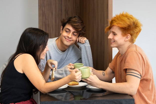 Gente sonriente sentada en la mesa de tiro medio