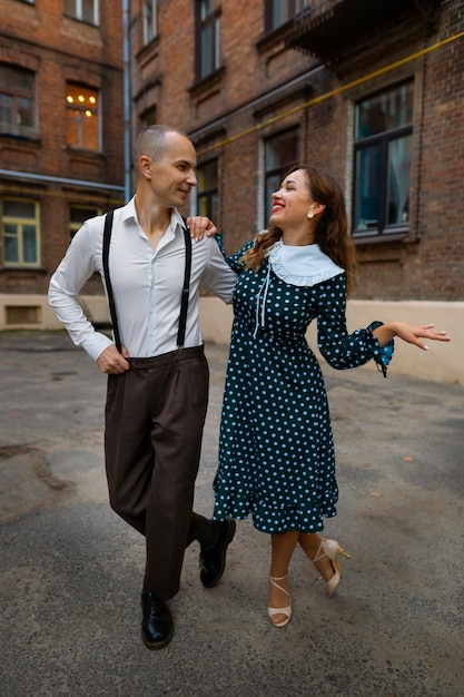 Foto gratuita gente sonriente de tiro completo bailando al aire libre