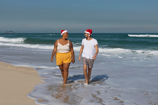 Gente sonriente de tiro completo caminando en la playa