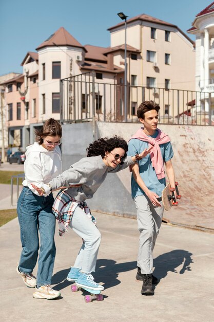 Foto gratuita gente sonriente de tiro completo con patines