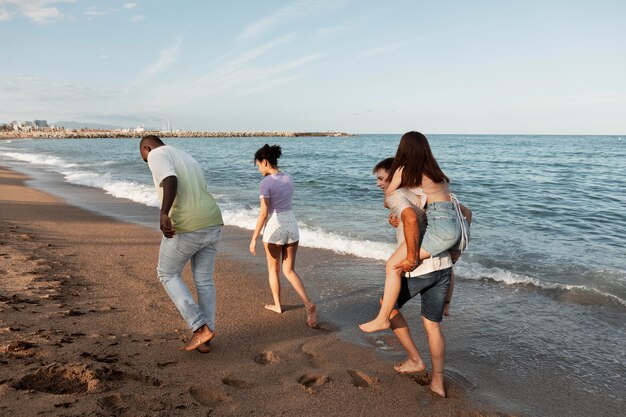 Gente sonriente de tiro completo en la playa