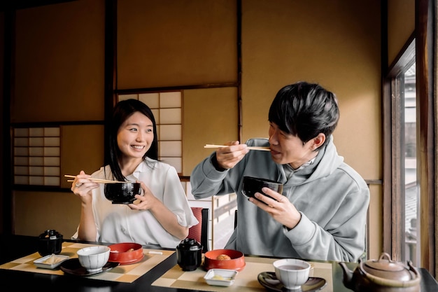 Gente sonriente de tiro medio comiendo juntos