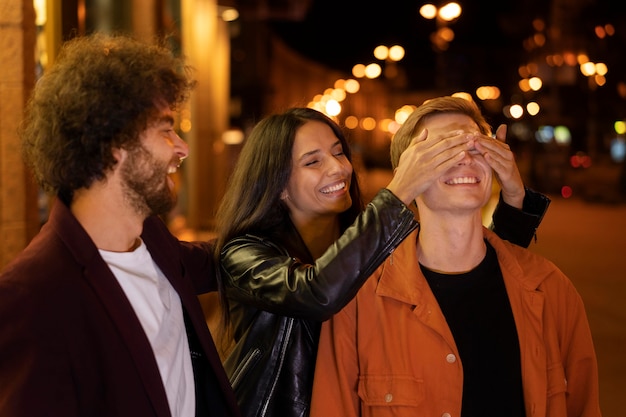 Foto gratuita gente sonriente de tiro medio en la noche