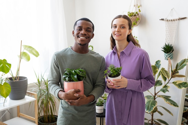 Gente sonriente de tiro medio con plantas