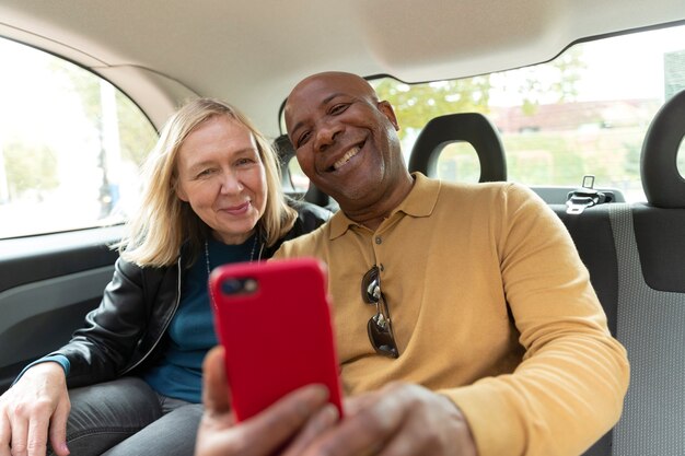 Gente sonriente con tiro medio de smartphone