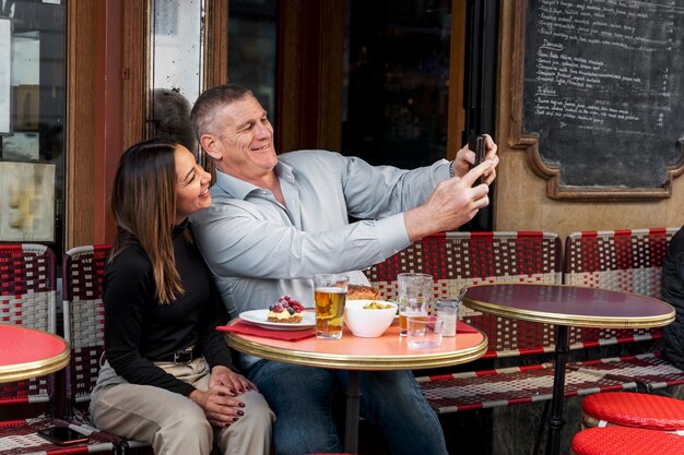 Gente sonriente de tiro medio tomando selfie