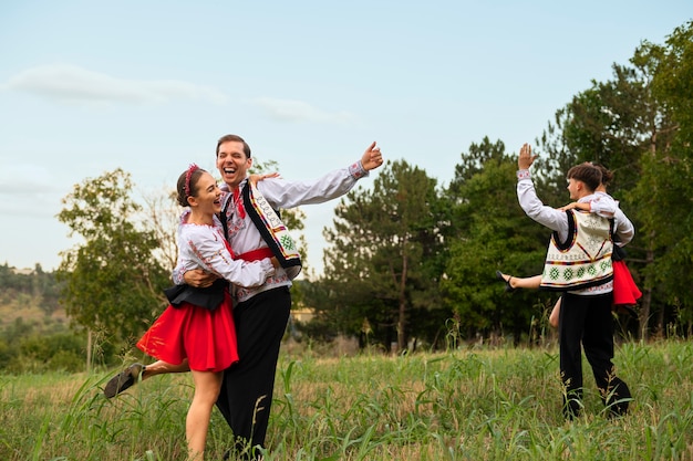 Gente de tiro completo bailando al aire libre