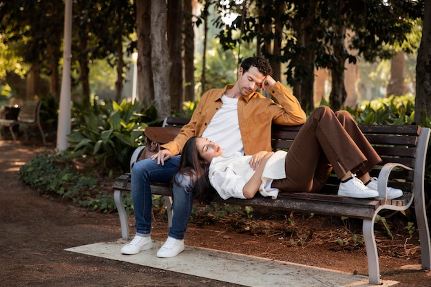 Foto gratuita gente de tiro completo en banco durmiendo