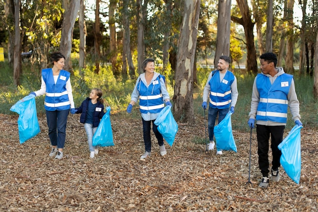 Foto gratuita gente de tiro completo con bolsas de basura