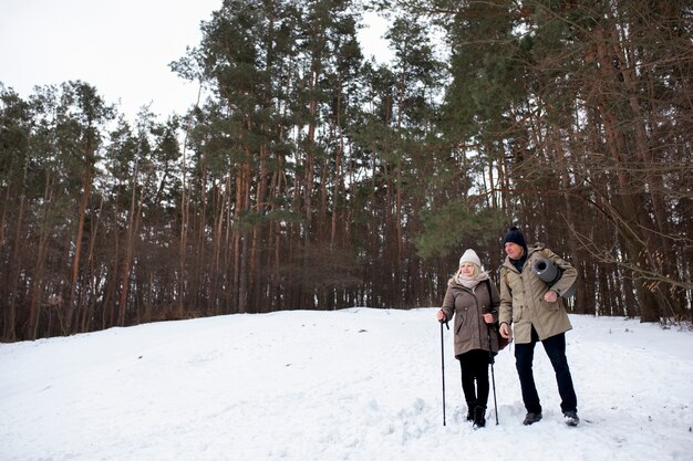 Gente de tiro completo caminando en la nieve