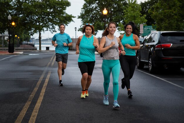 Gente de tiro completo corriendo juntos al aire libre