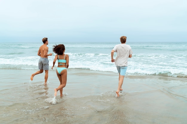 Gente de tiro completo corriendo en la playa