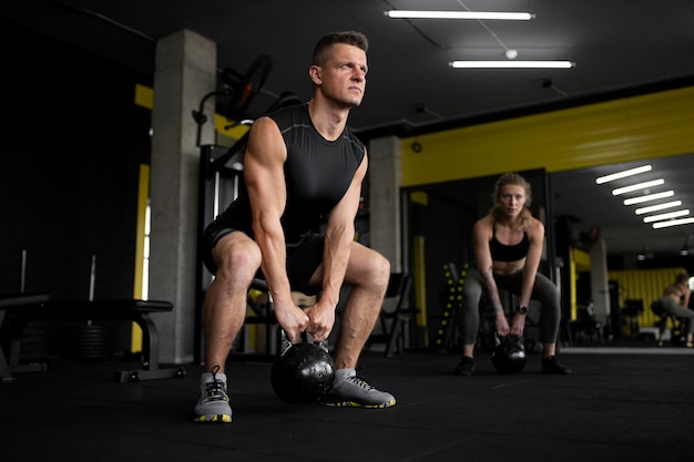 Gente de tiro completo entrenando en el gimnasio