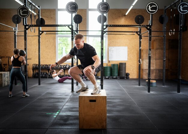 Gente de tiro completo entrenando en el gimnasio