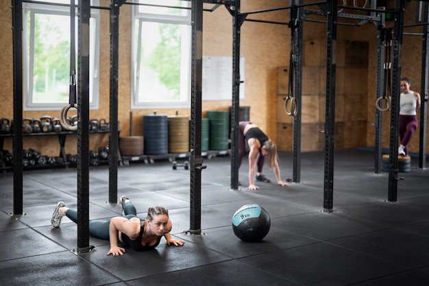 Gente de tiro completo entrenando en el gimnasio