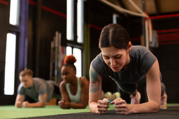 Gente de tiro completo entrenando juntas en el gimnasio