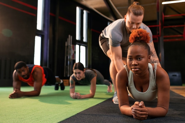 Gente de tiro completo entrenando juntas en el gimnasio