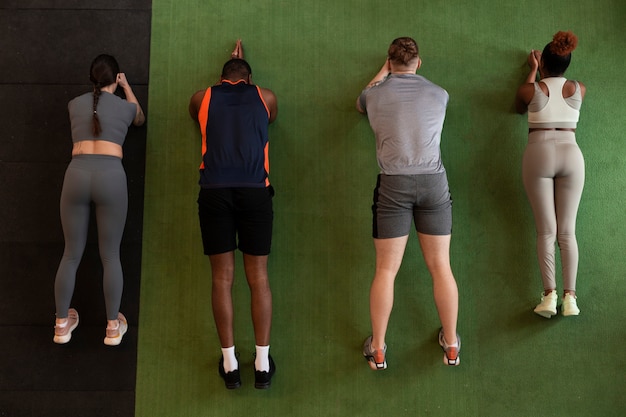 Gente de tiro completo entrenando juntas en el gimnasio