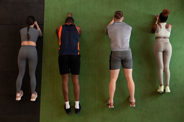 Gente de tiro completo entrenando juntas en el gimnasio