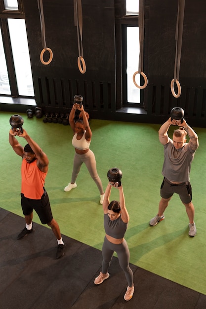 Gente de tiro completo entrenando juntas en el gimnasio