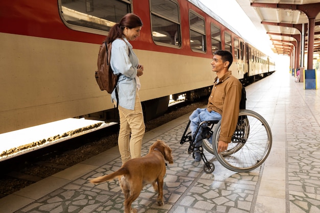 Gente de tiro completo en la estación de tren con perro