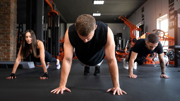 Gente de tiro completo haciendo burpees juntos