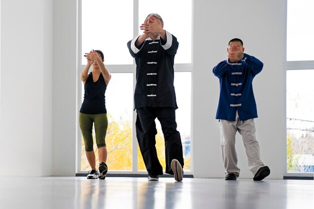 Foto gratuita gente de tiro completo practicando tai chi juntos