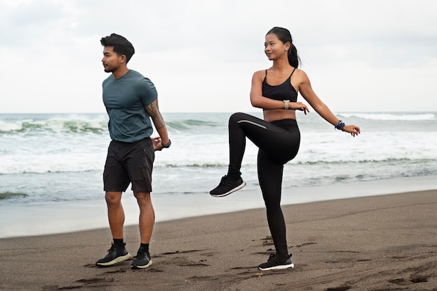 Gente de tiro completo que se extiende en la playa