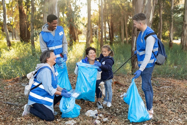 Foto gratuita gente de tiro completo recogiendo basura