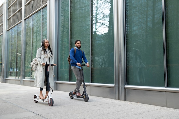 Gente de tiro completo con scooters eléctricos al aire libre.
