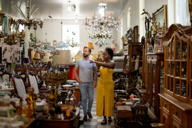 Gente de tiro completo en la tienda de antigüedades.