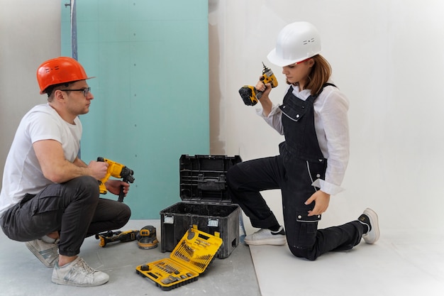 Gente de tiro completo trabajando con taladros.