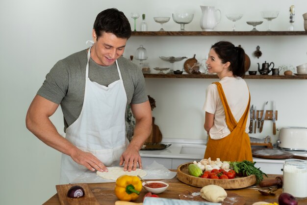 Gente de tiro medio cocinando pizza juntos