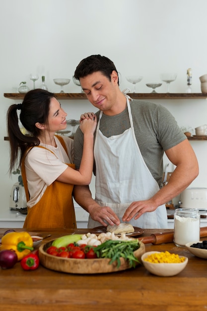 Foto gratuita gente de tiro medio cocinando pizza juntos