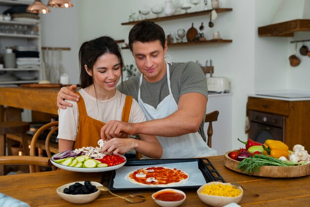 Gente de tiro medio cocinando pizza juntos