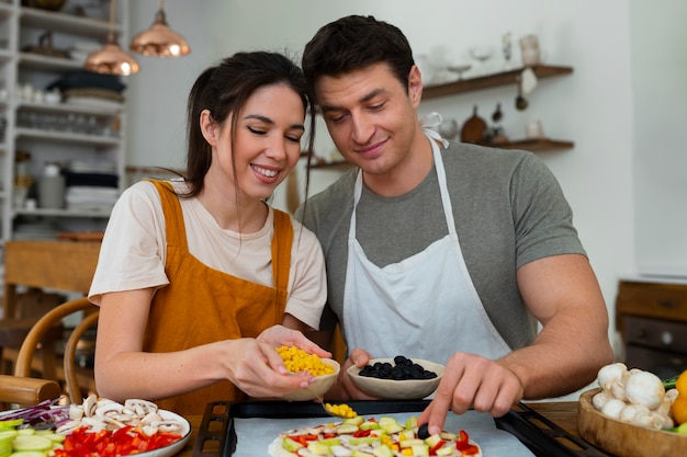 Gente de tiro medio cocinando pizza juntos