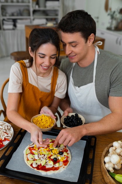 Gente de tiro medio cocinando pizza juntos