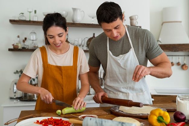 Gente de tiro medio cocinando pizza juntos