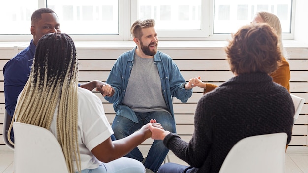 Foto gratuita gente de tiro medio cogidos de la mano en la reunión