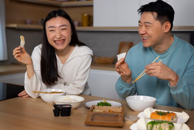 Gente de tiro medio comiendo comida asiática.