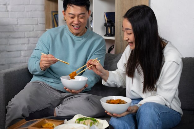 Gente de tiro medio comiendo comida asiática.