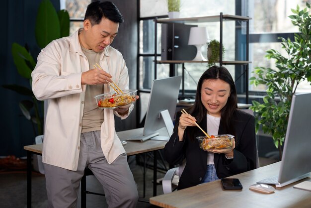 Gente de tiro medio comiendo comida asiática.