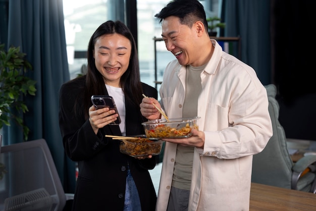 Foto gratuita gente de tiro medio comiendo comida asiática.