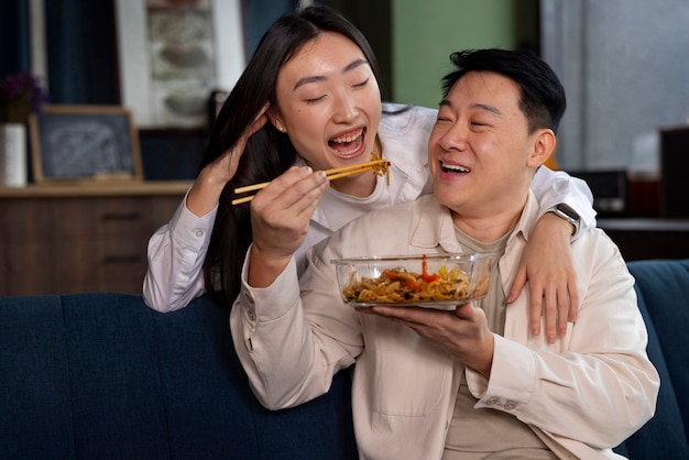 Gente de tiro medio comiendo comida asiática.