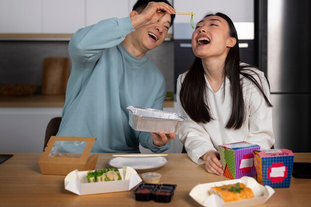 Gente de tiro medio comiendo comida asiática.