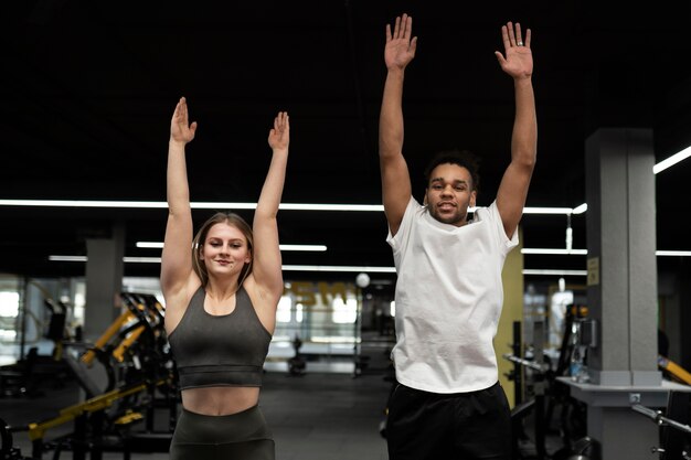 Gente de tiro medio haciendo burpees en el gimnasio