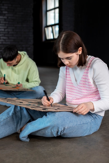 Gente de tiro medio haciendo pancartas en el piso