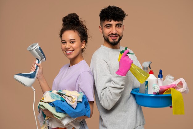 Foto gratuita gente de tiro medio haciendo tareas domésticas