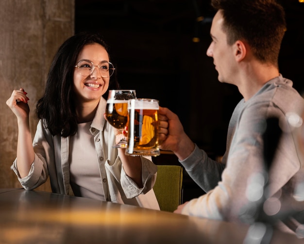 Gente de tiro medio con jarras de cerveza